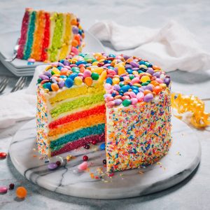 Our most frequently asked question might just be how to order this Rainbow Cake with Buttercream Icing and Candy Toppings!