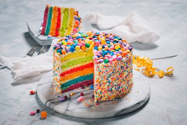 Our most frequently asked question might just be how to order this Rainbow Cake with Buttercream Icing and Candy Toppings!
