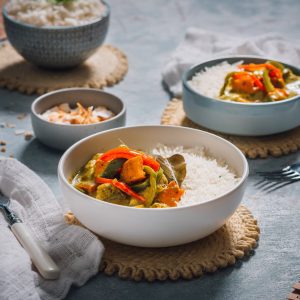 A table set with Chicken Thai Green Curry, served up in two bowls with some basmati rice.